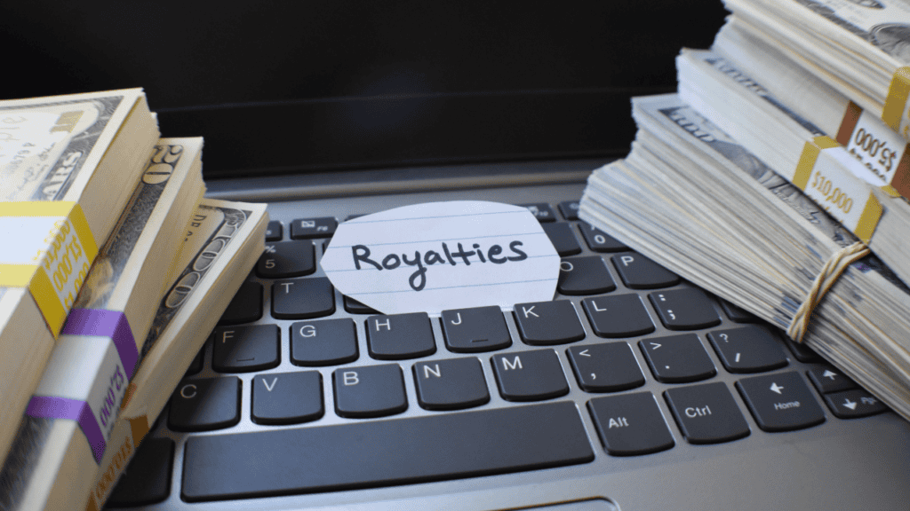 Keyboard with money bundles and a note labeled royalties.