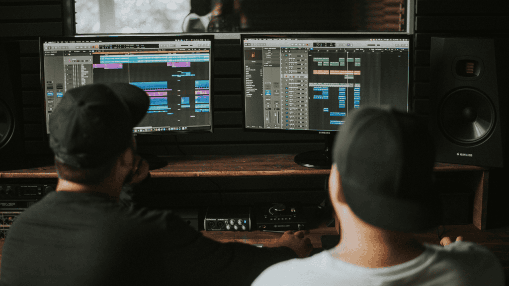 Music producers working on beat production in a studio.