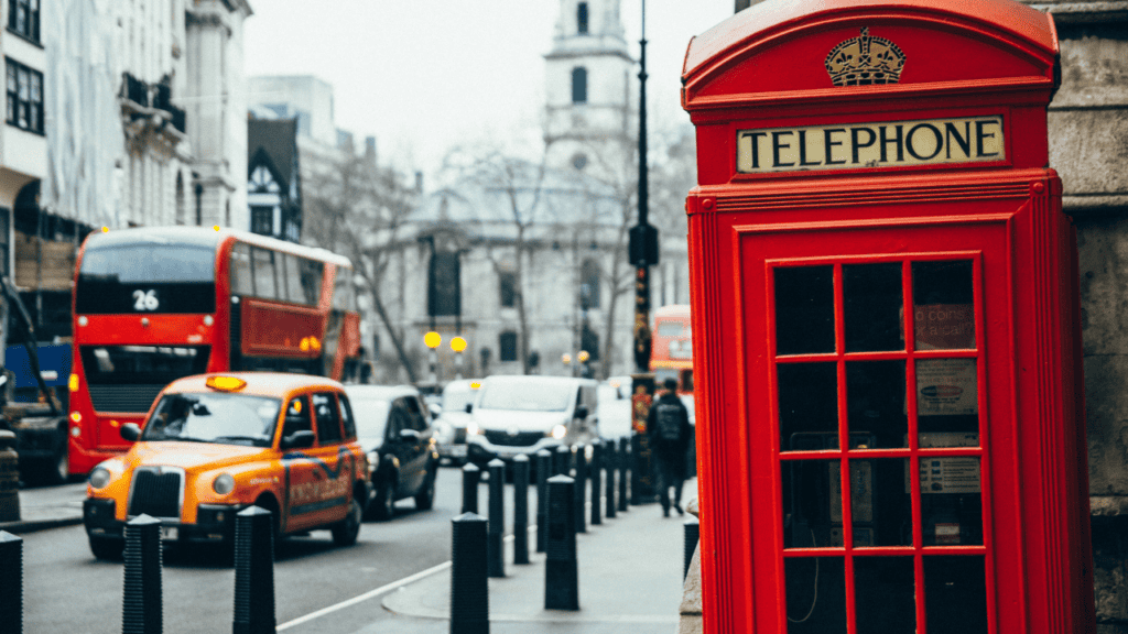 A classic red phone booth on a busy London street, representing the global reach of Amapiano.
