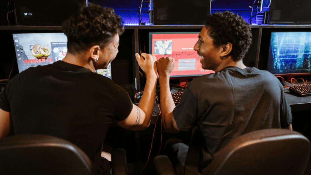 Two friends celebrating with a fist bump while gaming.